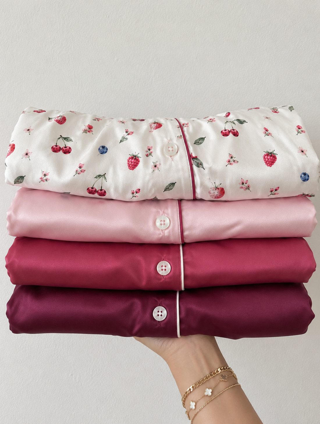 Four satin shirts folded in a stack